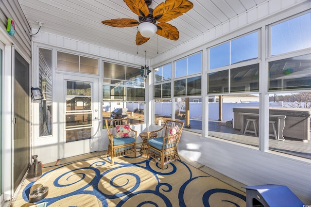 sunroom / solarium featuring ceiling fan, wooden ceiling, and a wealth of natural light