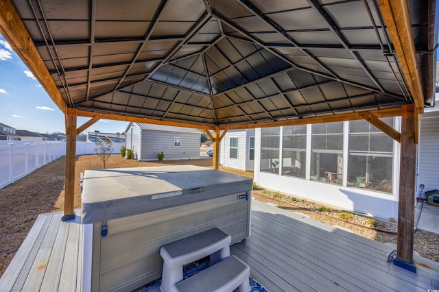 wooden deck featuring a gazebo, a sunroom, and a hot tub