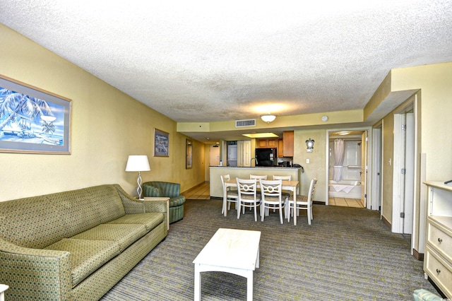 living room featuring dark colored carpet and a textured ceiling