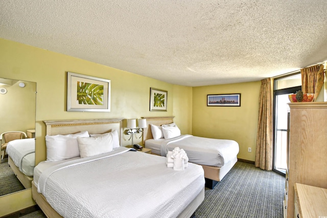 bedroom featuring dark colored carpet and a textured ceiling