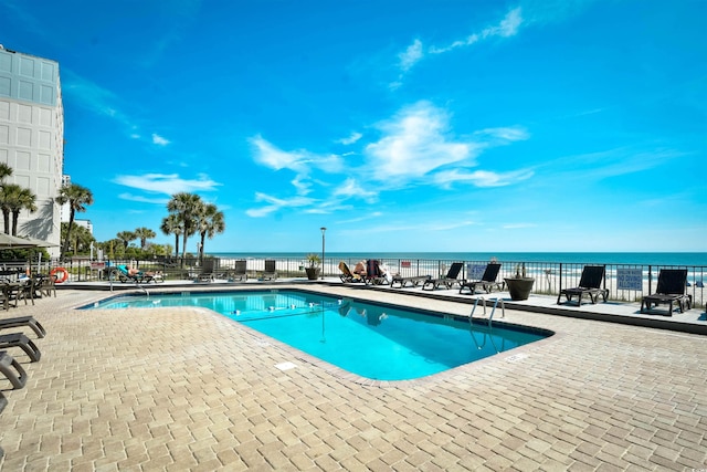 view of pool with a patio area and a water view