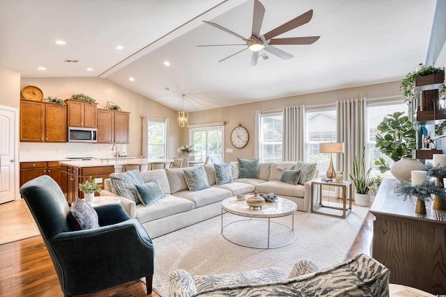 living room featuring ceiling fan, plenty of natural light, light hardwood / wood-style floors, and lofted ceiling