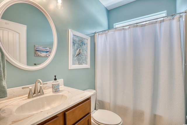 bathroom featuring curtained shower, vanity, and toilet