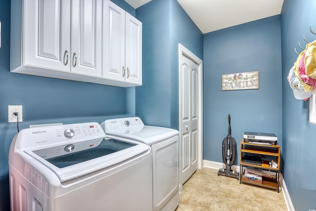 laundry area featuring washer and clothes dryer and cabinets