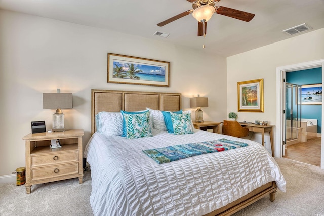 carpeted bedroom with ensuite bath and ceiling fan