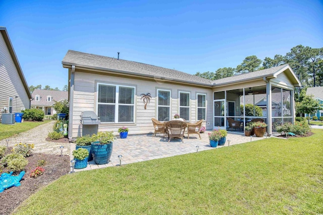 rear view of house with a sunroom, central AC unit, a patio area, and a lawn