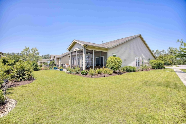 back of property with a yard and a sunroom