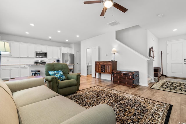 living room featuring ceiling fan and light hardwood / wood-style flooring