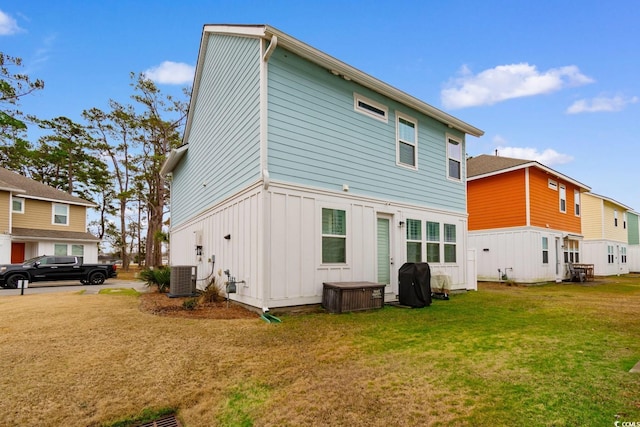 back of house featuring a lawn and central AC unit