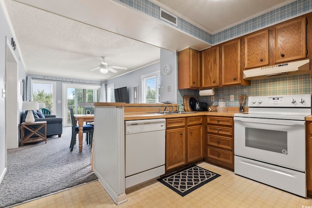 kitchen with kitchen peninsula, a textured ceiling, white appliances, ceiling fan, and sink