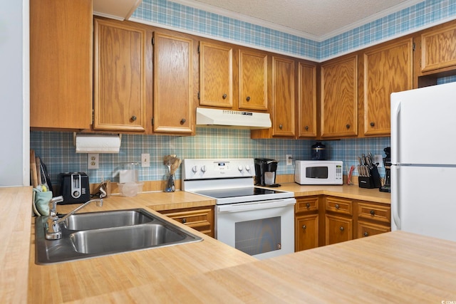 kitchen with a textured ceiling, decorative backsplash, white appliances, and sink