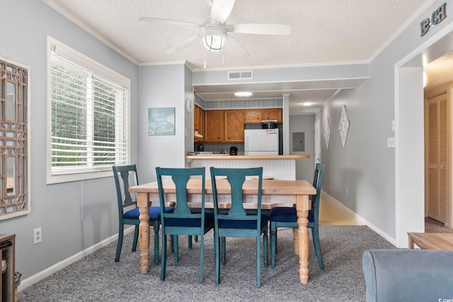 carpeted dining area featuring electric panel, crown molding, ceiling fan, and a textured ceiling