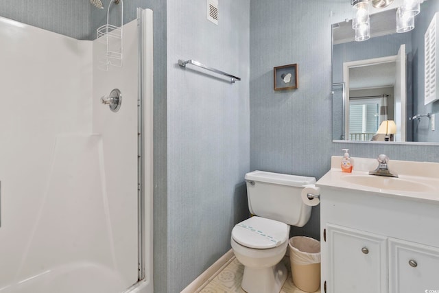 bathroom featuring vanity, toilet, and an enclosed shower