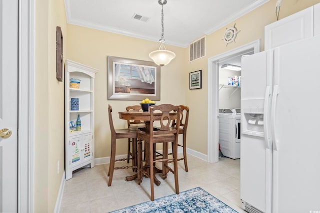 dining space featuring independent washer and dryer, light tile patterned floors, and ornamental molding