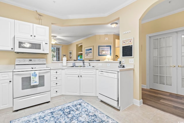 kitchen with white cabinetry, sink, light tile patterned floors, and white appliances