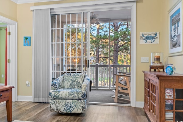 living area featuring ceiling fan, ornamental molding, and hardwood / wood-style flooring