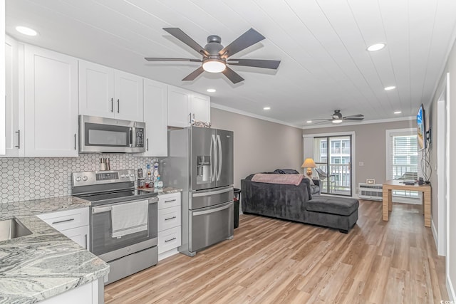 kitchen with light stone countertops, stainless steel appliances, and white cabinetry