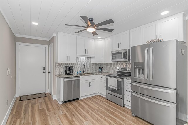 kitchen featuring white cabinetry, sink, ceiling fan, light hardwood / wood-style floors, and appliances with stainless steel finishes