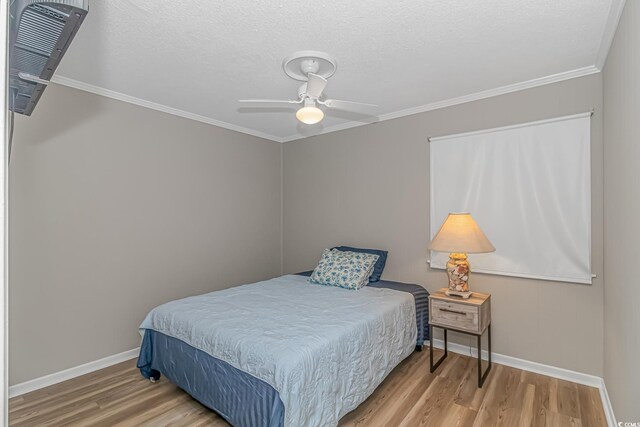 bedroom with ceiling fan, light hardwood / wood-style floors, ornamental molding, and a textured ceiling