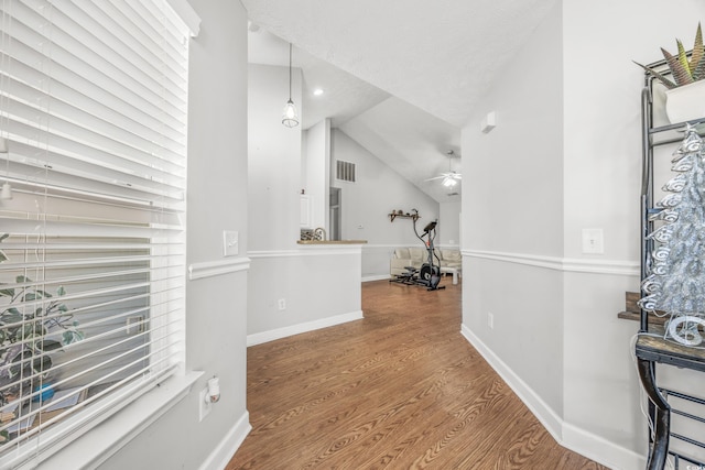 hallway featuring hardwood / wood-style floors and vaulted ceiling