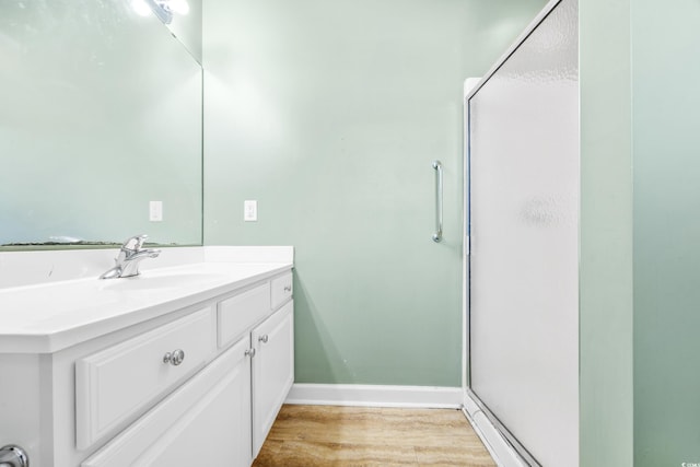 bathroom featuring hardwood / wood-style floors, vanity, and an enclosed shower