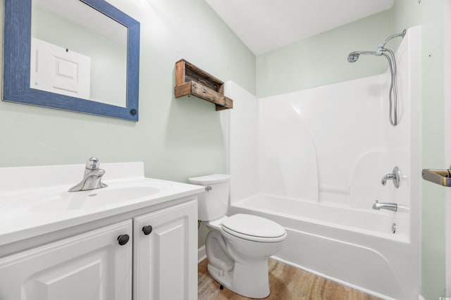 full bathroom featuring washtub / shower combination, vanity, hardwood / wood-style flooring, and toilet