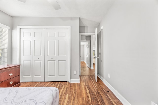 bedroom featuring hardwood / wood-style flooring, ceiling fan, and a closet