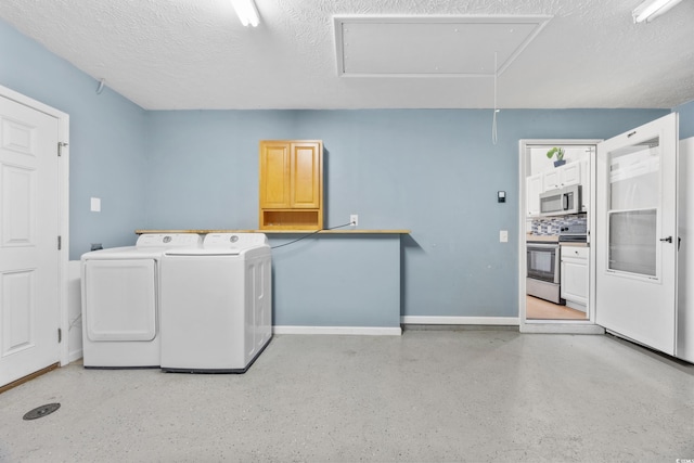 washroom with cabinets, independent washer and dryer, and a textured ceiling