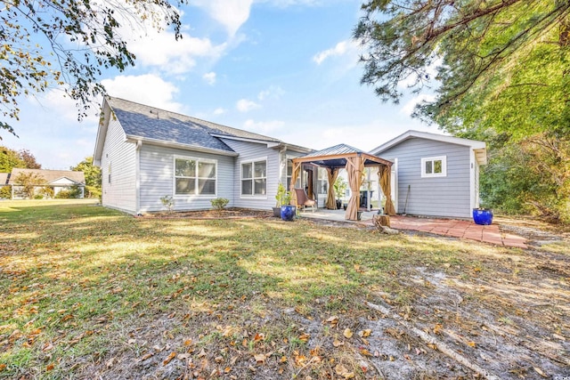 rear view of property with a gazebo, a yard, and a patio area