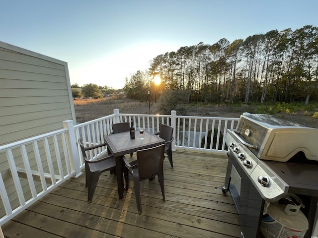 deck with outdoor dining area and grilling area