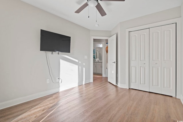 unfurnished bedroom featuring a ceiling fan, a closet, baseboards, and wood finished floors