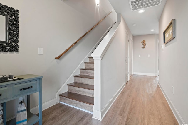 staircase featuring recessed lighting, wood finished floors, visible vents, and baseboards