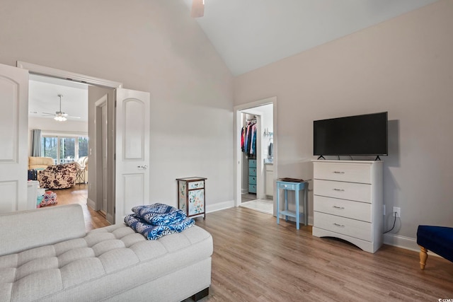 living room featuring ceiling fan, high vaulted ceiling, light wood finished floors, and baseboards