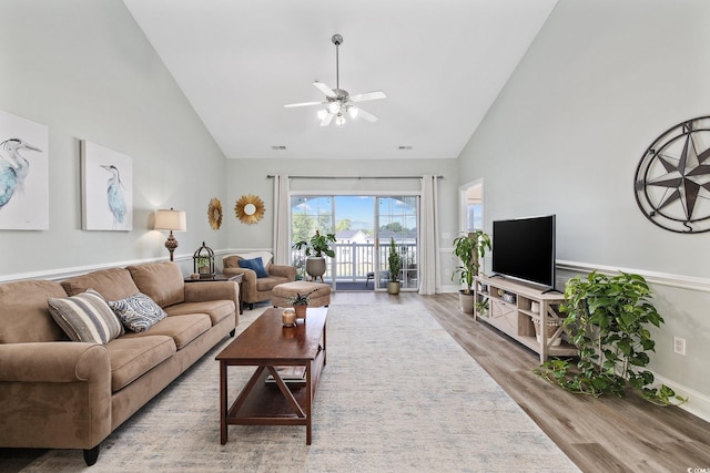 living room with hardwood / wood-style floors, high vaulted ceiling, and ceiling fan