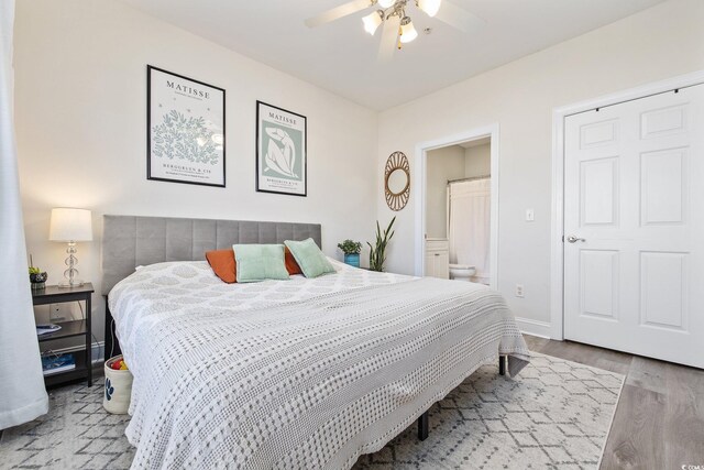 bedroom with ensuite bathroom, ceiling fan, and hardwood / wood-style flooring