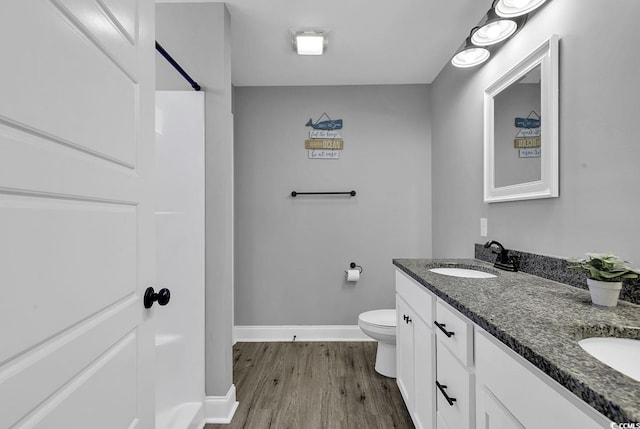 bathroom with hardwood / wood-style flooring, vanity, and toilet