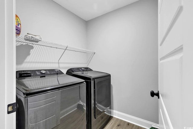 laundry area featuring washing machine and clothes dryer and wood-type flooring