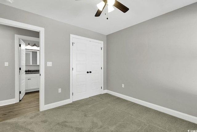 unfurnished bedroom with ceiling fan, dark carpet, and a closet