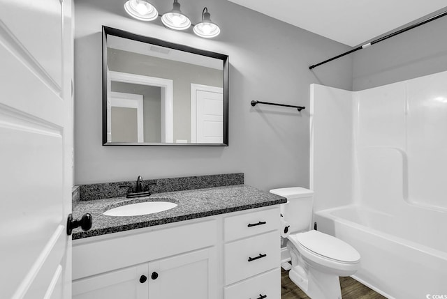 full bathroom featuring bathtub / shower combination, hardwood / wood-style floors, vanity, and toilet