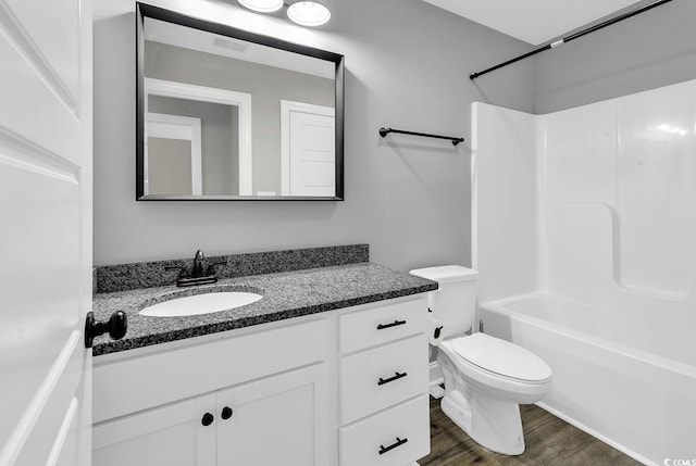 full bathroom featuring shower / bathing tub combination, vanity, wood-type flooring, and toilet