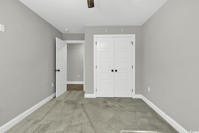 unfurnished bedroom with ceiling fan, a closet, and light carpet