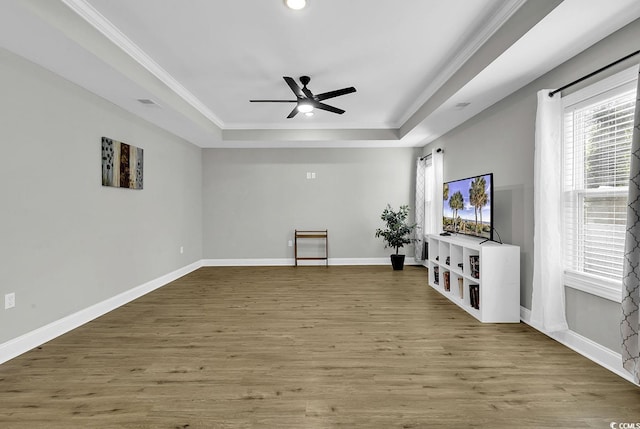 unfurnished living room featuring a raised ceiling, plenty of natural light, and wood-type flooring