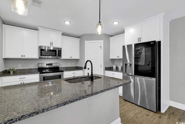 kitchen with sink, white cabinets, decorative light fixtures, and appliances with stainless steel finishes