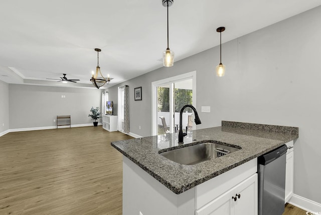 kitchen featuring stainless steel dishwasher, ceiling fan, sink, dark stone countertops, and white cabinets