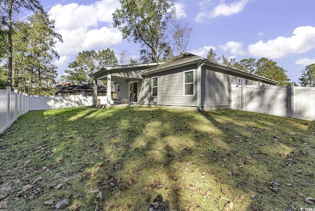 rear view of property with a yard