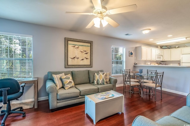 living room featuring ceiling fan and dark wood-type flooring