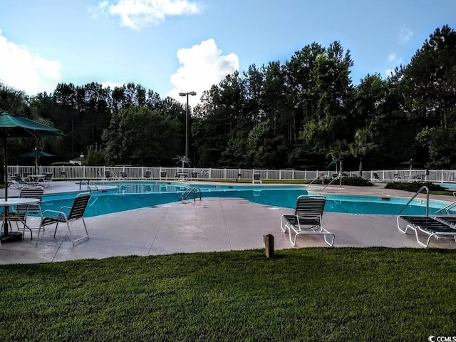 view of pool with a lawn and a patio area