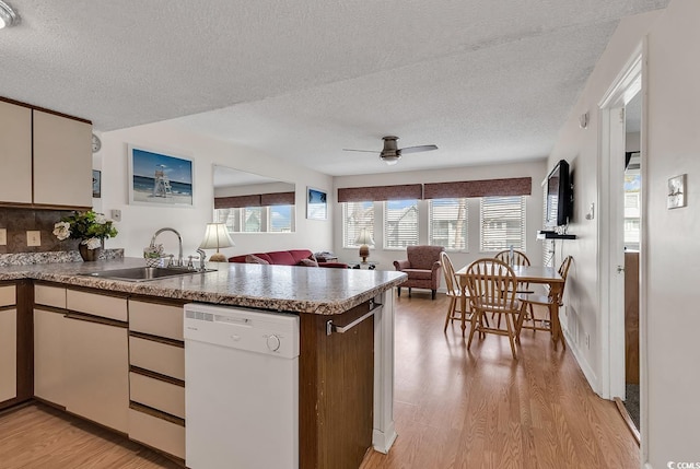 kitchen featuring decorative backsplash, kitchen peninsula, a textured ceiling, sink, and dishwasher