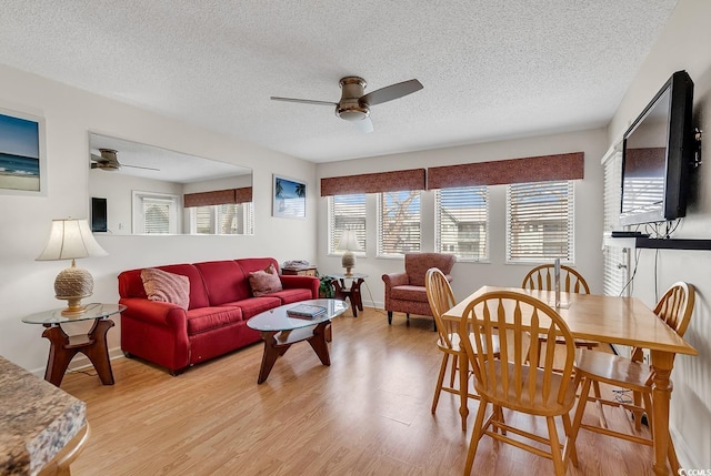 dining space featuring ceiling fan, light hardwood / wood-style floors, and a textured ceiling