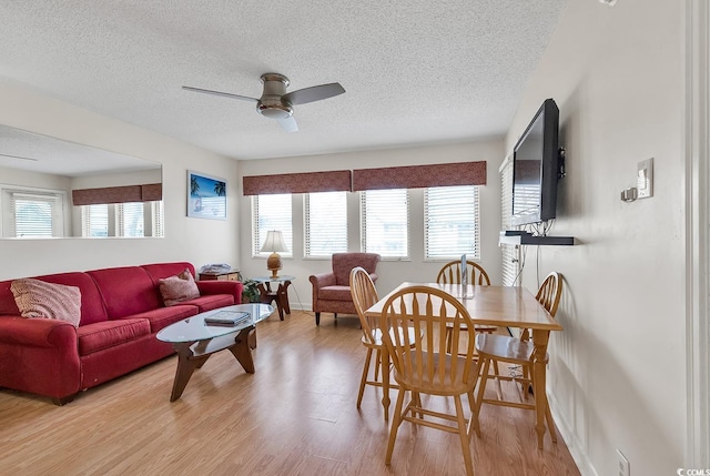 dining space featuring ceiling fan, light hardwood / wood-style flooring, and a textured ceiling